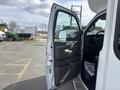 White 2018 Chevrolet Express van with the driver's side door open displaying the interior controls and a part of the seat