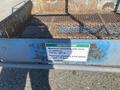 A weathered metal platform with a mesh floor and a green and white instruction label detailing weight limits and wind speed restrictions