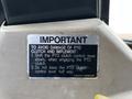 A metallic warning label on a machinery control panel providing important instructions for operating the PTO clutch and implement