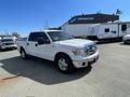 A 2012 Ford F-150 pickup truck in white with a silver grille and chrome accents parked at an outdoor location