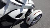 A white 2013 Can-Am Spyder showcasing its distinctive three-wheeled design with a prominent front and sleek lines