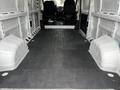 Interior view of a 2021 RAM Promaster van showing a spacious empty cargo area with a flat black floor and wheel wells on either side