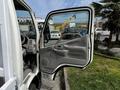 The image features the open driver's door of a 2004 Toyota Toyoace showcasing the interior controls and seating area