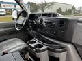 Interior view of a 2011 Ford Econoline showcasing the dashboard with various controls and a central console featuring cup holders