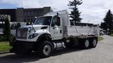 A white 2014 International 7500 dump truck with a large bed for transporting materials and a front grille with prominent chrome accents