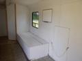 Interior of a 2004 Royal 18 foot office trailer featuring a storage bench along one wall and a mounted whiteboard on the opposite side