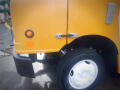 Close-up of a yellow 2008 Freightliner MT45 Chassis showing the front wheel and part of the vehicle's body with visible rivets and a side marker light