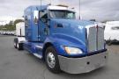 A blue 2015 Kenworth T660 semi-truck with a chrome grille and prominent headlights parked at an angle with a visible truck number 747 on the side
