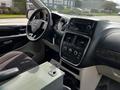 Interior view of a 2011 Dodge Grand Caravan showcasing the dashboard steering wheel and center console with control buttons and a display screen