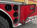 A red 2009 Spartan Gladiator fire truck with four large circular vents on the side and an open compartment door revealing the interior structure of the vehicle