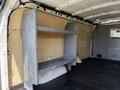 A 2017 GMC Savana cargo van interior featuring a metal shelving unit mounted against the side wall