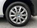 Close-up of a silver alloy wheel from a 2014 Ford Transit Connect showing five spokes and a blue Ford emblem in the center