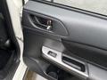 Interior door panel of a 2016 Subaru Crosstrek featuring a door handle power window controls and textured armrest with a black and silver color design