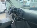 Interior view of a 2004 Ford Econoline showing the driver's seat steering wheel and dashboard with controls and storage compartments