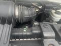 Engine compartment of a 2004 Ford Econoline showing the air intake and various components including tubing and a fluid reservoir