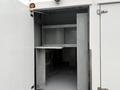 A 2014 International TerraStar with its rear door open revealing a spacious gray interior featuring shelves and a flat surface