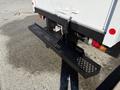 A black flatbed step with a honeycomb pattern attached to the rear of a 2014 Hino 195 truck