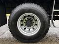 A close-up of a tire mounted on a 2017 Freightliner M2 106 featuring a silver wheel rim and multiple bolt holes