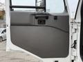 Door panel of a 2009 UD Trucks UD 3300 featuring a textured gray surface with a handle and a window control button