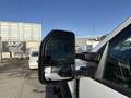 A 2020 Ford F-550 side mirror reflecting a nearby vehicle and showing its black border and multiple adjustment settings