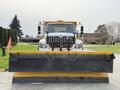 A 2016 International 7600 truck equipped with a large yellow snow plow attached to the front