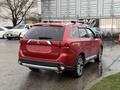 Red 2016 Mitsubishi Outlander parked with visible rear features including tail lights and a roof rack