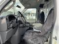 Interior of a 2008 Ford Econoline showing the driver and passenger seats covered in black fabric with a steering wheel and dashboard visible