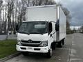 A white 2019 Hino 195 box truck is parked, featuring a flat front and a tall cargo area with a blank white exterior