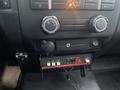 Interior dashboard controls of a 2013 Ford F-150 featuring climate control knobs and a mounted electronic device with lights and buttons