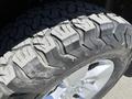 A close-up of a rugged tire from a 2015 RAM 1500 showcasing deep treads and metallic alloy wheel rim