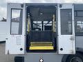 The rear entrance of a 2016 Chevrolet Express with an open door and a yellow wheelchair ramp extended out