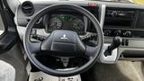 Steering wheel and dashboard of a 2018 Mitsubishi Fuso FE with control displays and a radio console visible