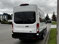 A white 2021 Ford Transit van with a high roof and rear doors viewed from the back