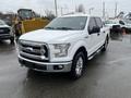 A white 2016 Ford F-150 pickup truck with chrome accents and running boards parked outdoors