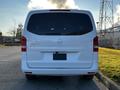 A white 2022 Mercedes-Benz Metris viewed from the rear with a sleek design and large tinted windows