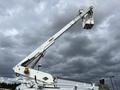 A 2008 Ford Econoline equipped with a white articulated boom lift with a bucket at the end used for elevated work on utility poles or buildings