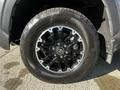 A close-up view of a 2023 Toyota Tundra's wheel featuring a black alloy rim and a rugged tire with visible tread pattern