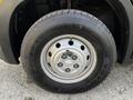 Close-up of a tire on a 2019 RAM Promaster featuring a silver steel wheel with six circular holes and a tire labeled Open Country mounted on it