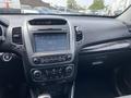 Dashboard of a 2015 Kia Sorento featuring a touchscreen display radio climate controls and various buttons and knobs