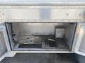 A metal storage compartment of a 2007 Morgan Olson Workhorse W42 with open doors showing an empty interior and visible wiring