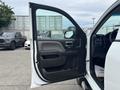 A 2016 GMC Sierra 1500 with the driver's door open showcasing the interior features and controls