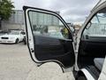 A 2009 Toyota Hiace with an open driver's side door showcasing the interior and seating area