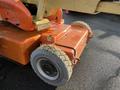 A close-up view of a 2012 JLG E400AJFN electric boom lift showing its orange base and large rubber tires designed for outdoor use