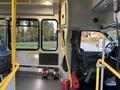 Interior view of a 2019 Chevrolet Express showing driver's seat and controls with yellow handrails and a spacious passenger area
