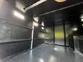 Interior view of a 2012 Freightliner M2 106 showcasing a black cargo area with smooth walls and ceiling illuminated by several recessed lights