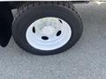 A close-up of a white wheel with a silver hubcap and a thick black tire on a 2008 Ford F-450 SD