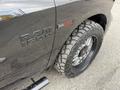 A black 2018 RAM 1500 with an EcoDiesel badge and off-road tires showcasing a rugged design and bold lettering on the side