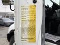 A yellow vehicle specifications label attached to the side of a 2006 International 4200 truck displaying various specifications and identifiers