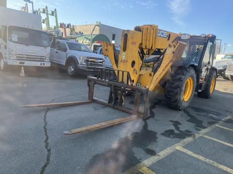 A 2013 JCB 510-56 Loadall with a yellow and black frame features large wheels and a front-mounted forklift attachment with extended prongs