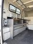 A 2014 Ford F-350 SD interior with metal shelving units installed in the cargo area and various utility equipment visible